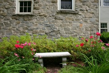 Stone house with concrete bench and perennials